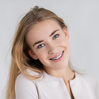 Young girl with traditional braces smiling