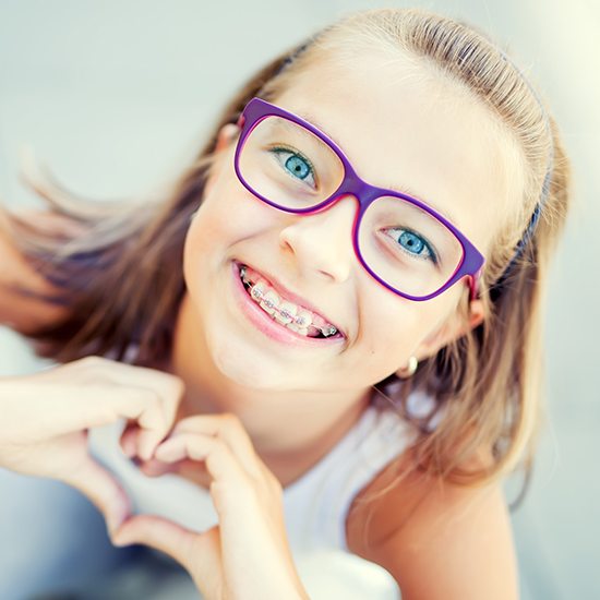 Preteen girl with pediatric orthodontics smiling