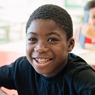 Preteen boy with pediatric orthodontics smiling