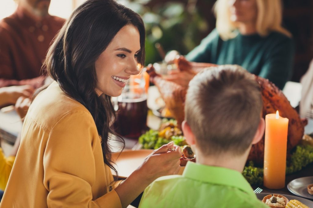 Woman smiling at son during Thanksgiving meal
