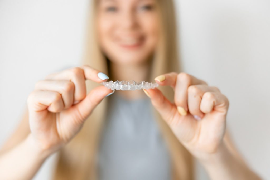 Closeup of woman holding Invisalign aligner